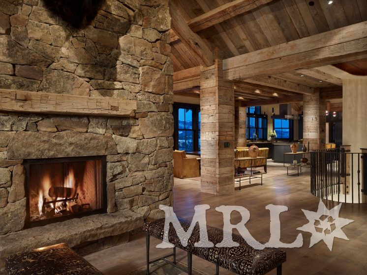 A photo of our reclaimed hand hewn timbers and slabs used to clad posts, coffer ceilings, frame entrances, and side the exterior along with corral board accents featured throughout the Ranch 1 project.