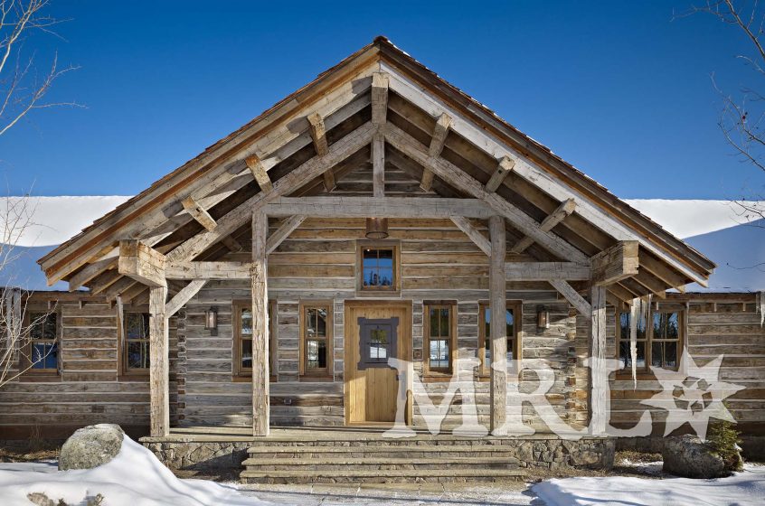 A photo of our reclaimed hand hewn timbers and slabs used to clad posts, coffer ceilings, frame entrances, and side the exterior along with corral board accents featured throughout the Ranch 1 project.