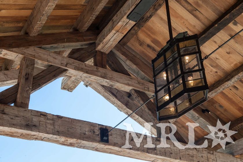 A photo of our oak ceiling paneling and hand-hewn timbers inside and out of the Legacy Ranch project.